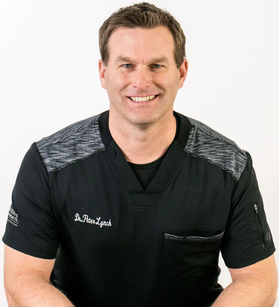 Dr. Peter Lynch, chiropractor in Dubuque, smiling in Tri-States Chiropractic scrubs