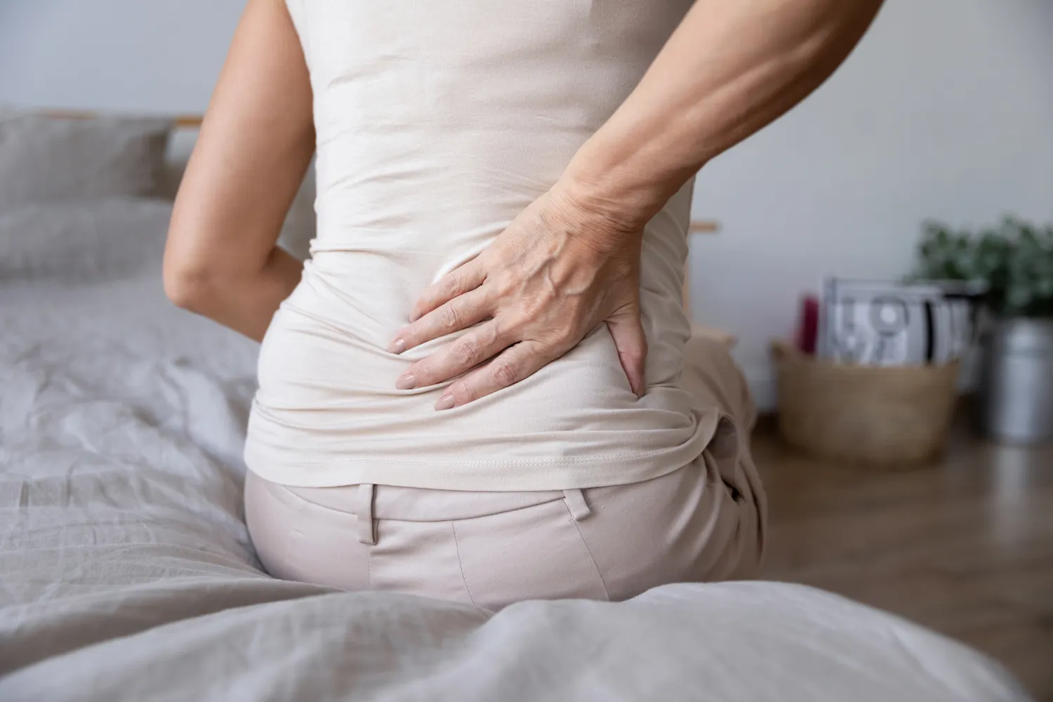 woman sit in bed suffer from sciatica pain
